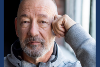 Headshot of person with a beard, resting head on hand